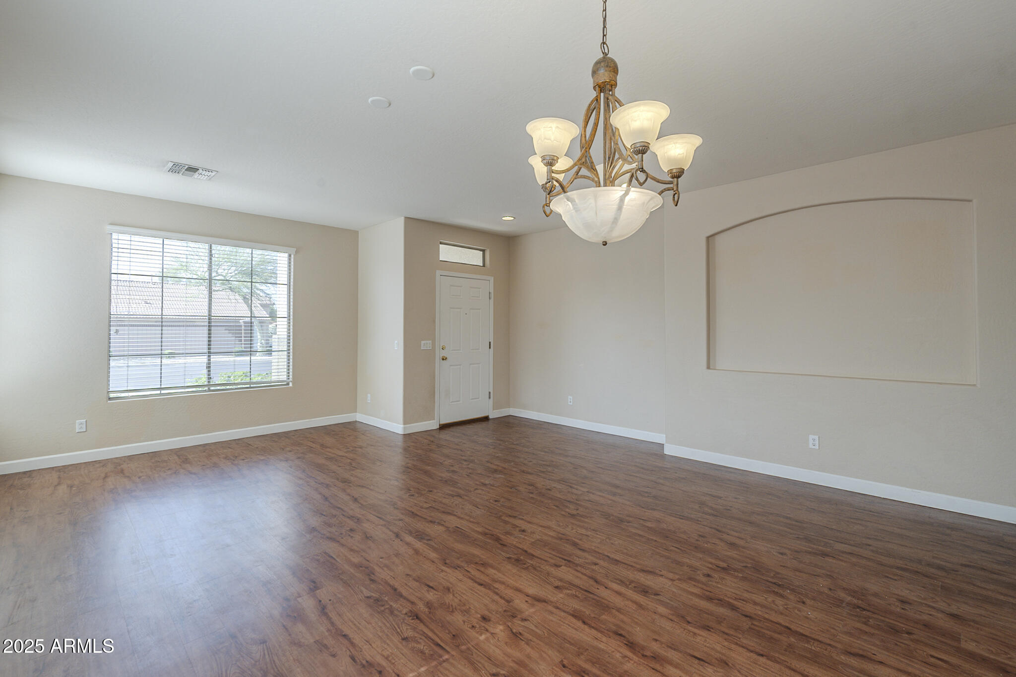 15902 West Hearn Road Surprise, AZ 85379 - Photo 5 of 73 an empty room with wooden floor fan and windows