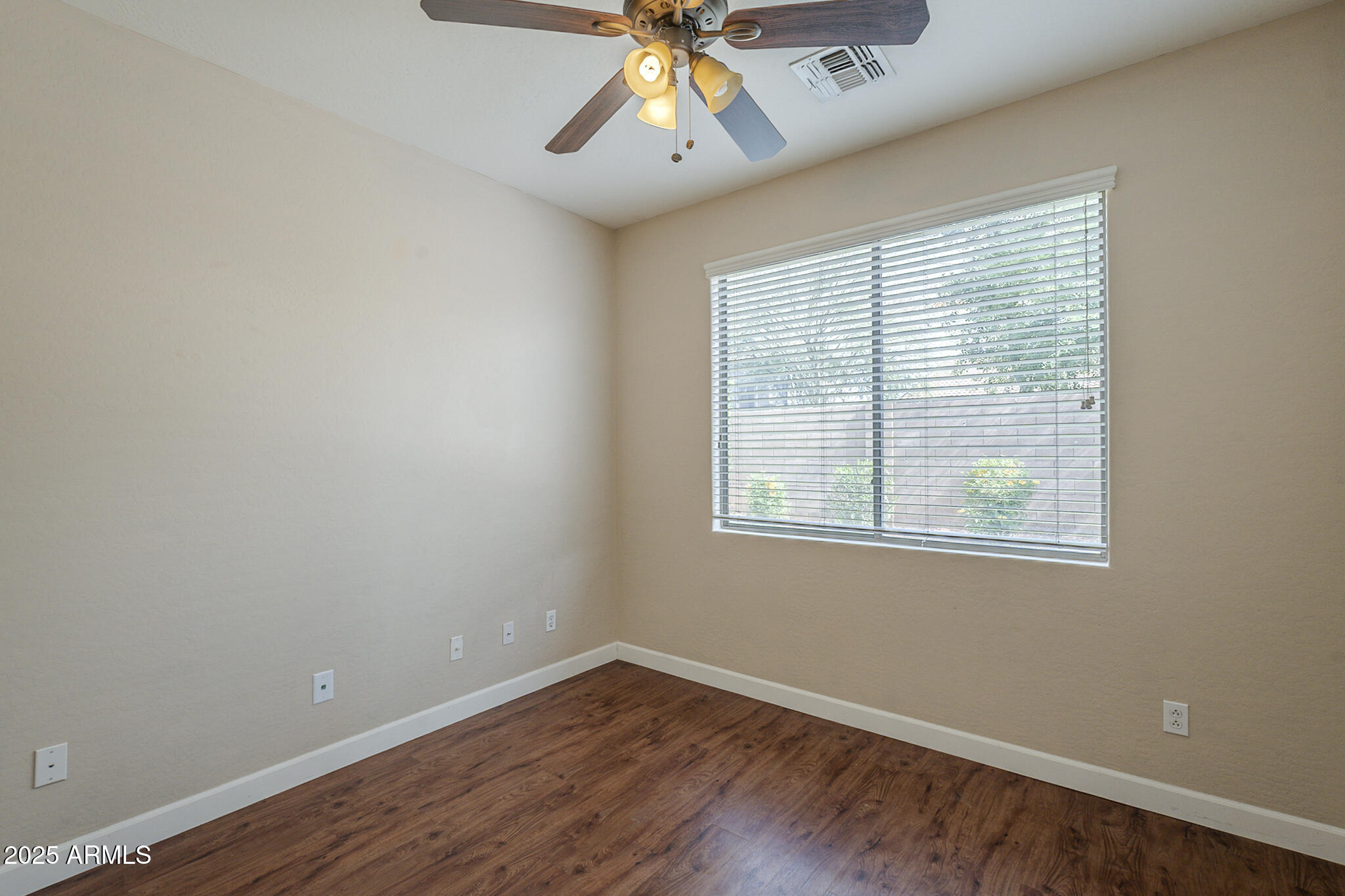 15902 West Hearn Road Surprise, AZ 85379 - Photo 53 of 73 a view of an empty room with wooden floor and a window
