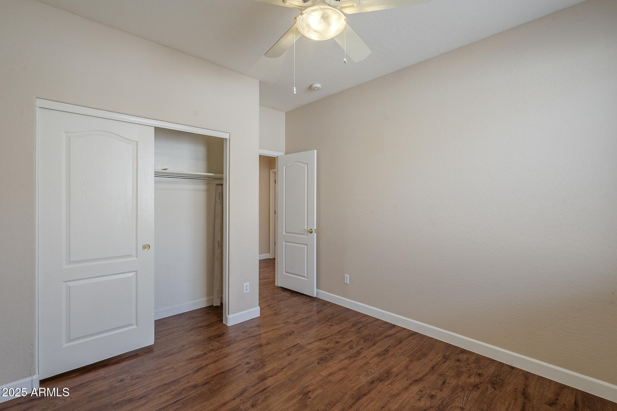 15902 West Hearn Road Surprise, AZ 85379 - Photo 56 of 73 an empty room with wooden floor and a ceiling fan