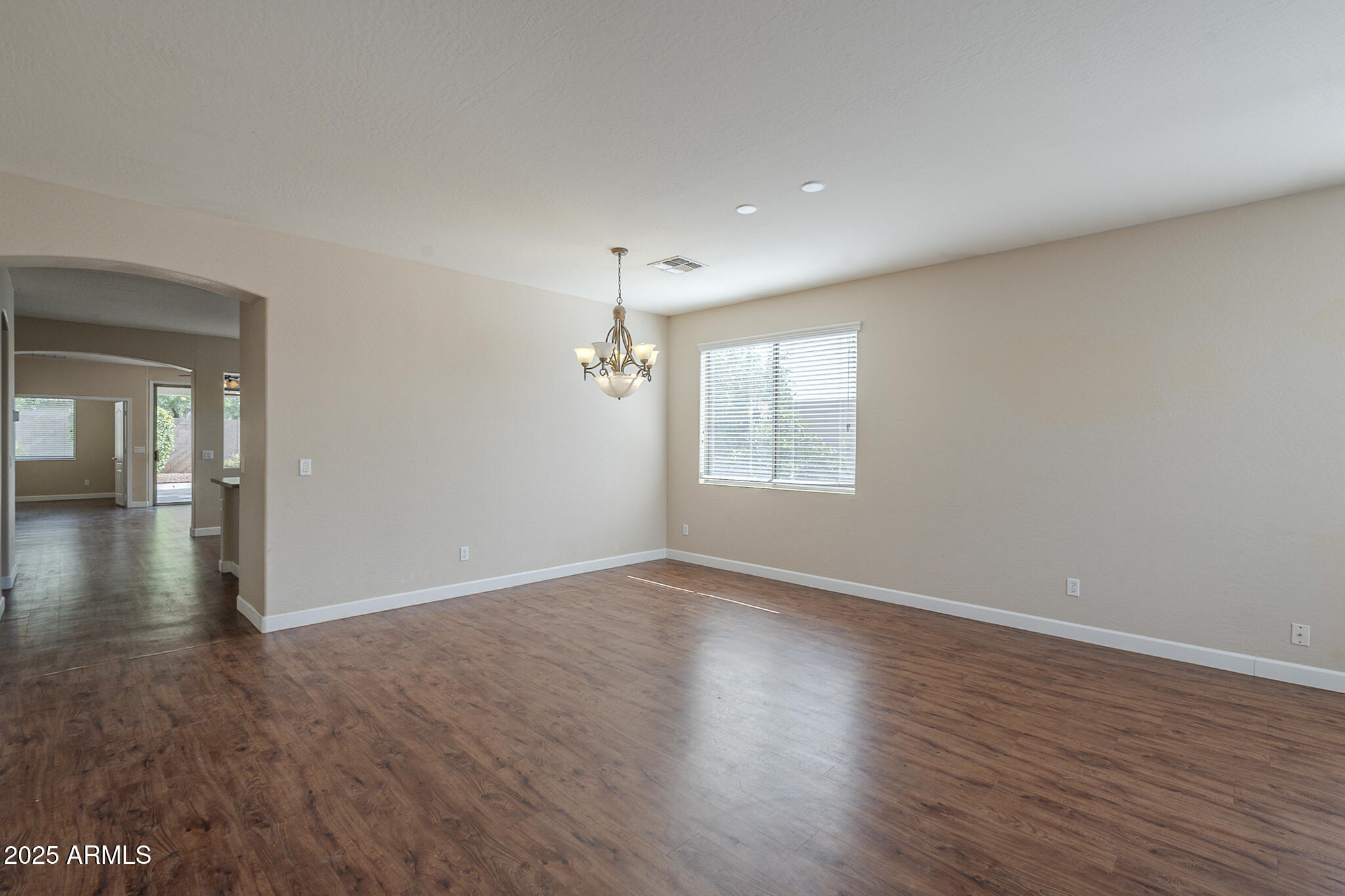 15902 West Hearn Road Surprise, AZ 85379 - Photo 6 of 73 an empty room with wooden floor and windows