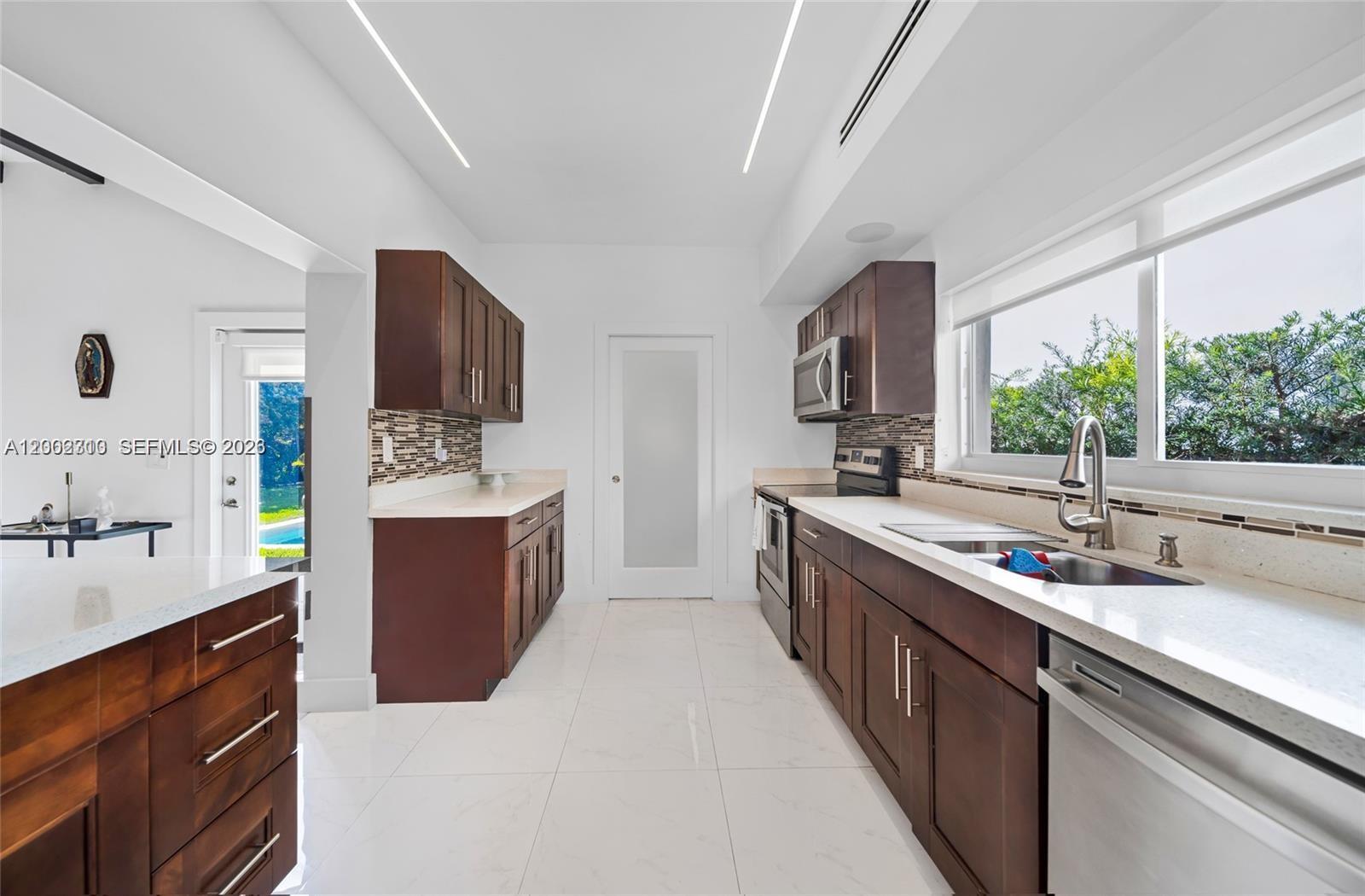 3531 Southwest 1st Avenue Miami, FL 33145 - Photo 7 of 44 a large kitchen with stainless steel appliances granite countertop a sink stove and refrigerator