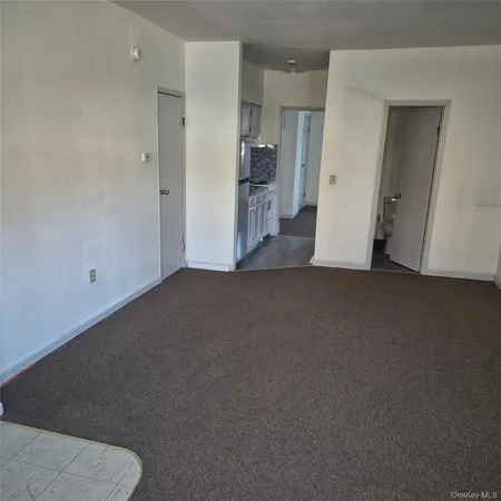 a view of empty room with furniture and refrigerator