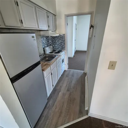 a kitchen with granite countertop white cabinets and white appliances