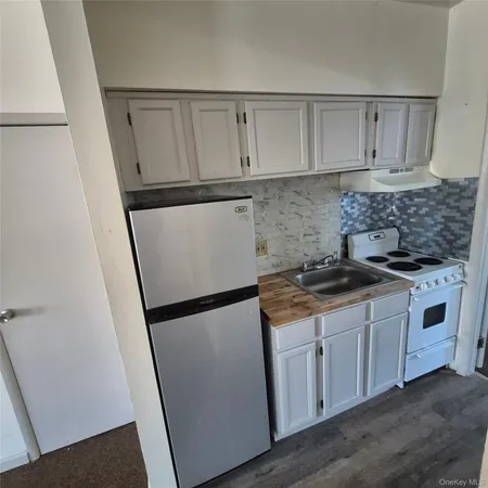 a kitchen with white cabinets and white appliances