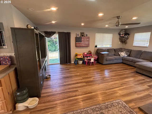 a living room with furniture floor to ceiling window and wooden floor