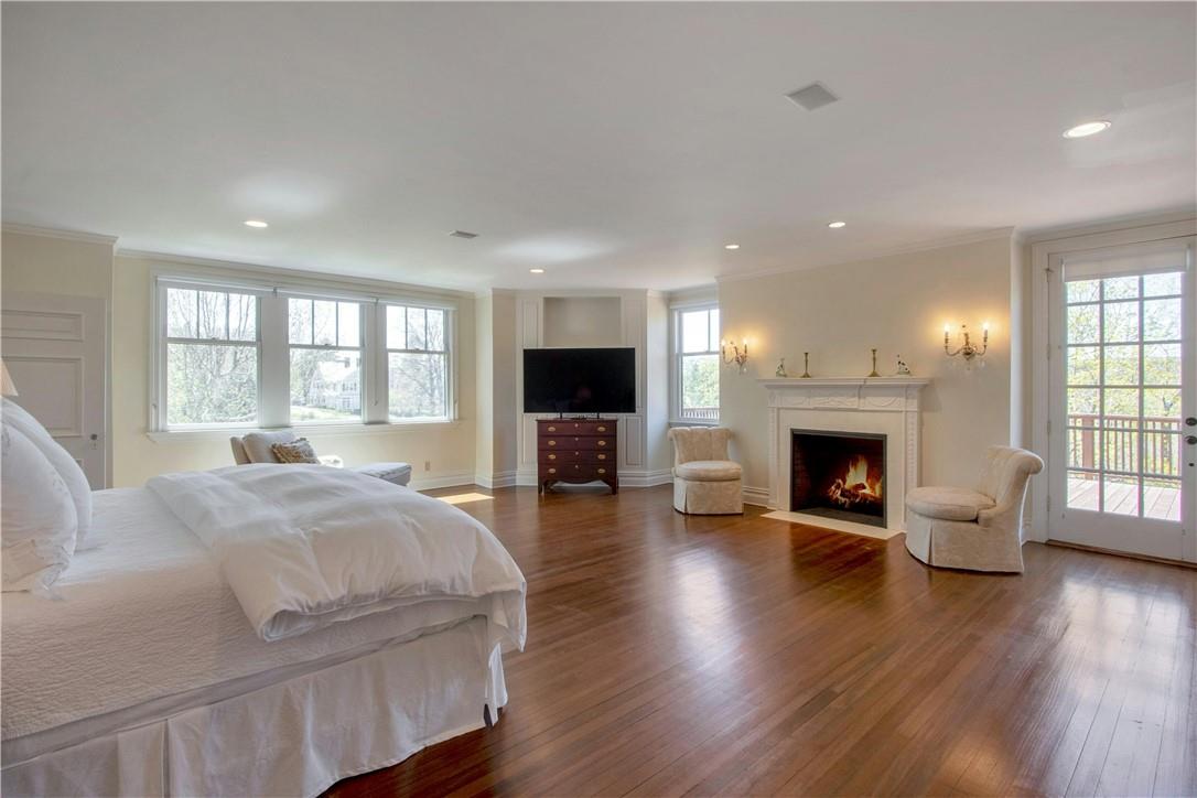 122 Circuit Road Tuxedo Park, NY 10987 - Photo 20 of 35 a spacious bedroom with a balcony a bed and a flat screen tv