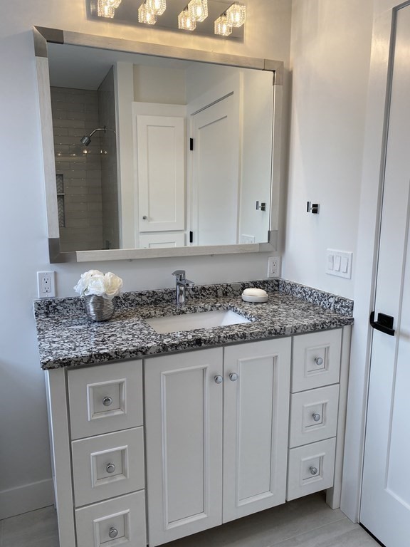 4 Wells Street Natick, MA 01760 - Photo 27 of 38 a bathroom with a granite countertop double vanity sink and mirror