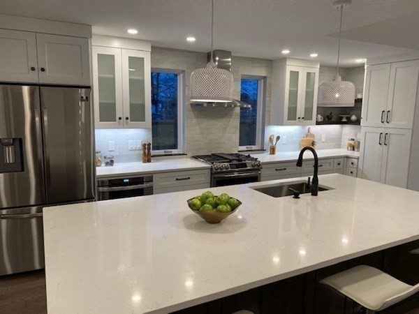 4 Wells Street Natick, MA 01760 - Photo 5 of 38 a kitchen with stainless steel appliances a sink a stove a refrigerator white cabinets and wooden floor