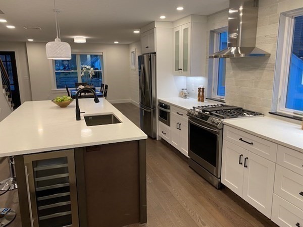 4 Wells Street Natick, MA 01760 - Photo 8 of 38 a kitchen with kitchen island stainless steel appliances a sink a stove a refrigerator and white cabinets
