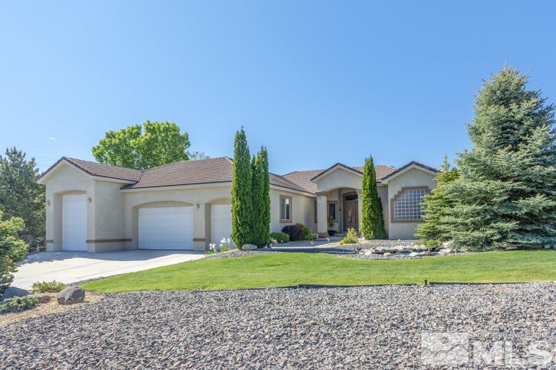 12670 Silver Wolf Road Reno, NV 89511 - Photo 1 of 25 a front view of a house with a yard and garage