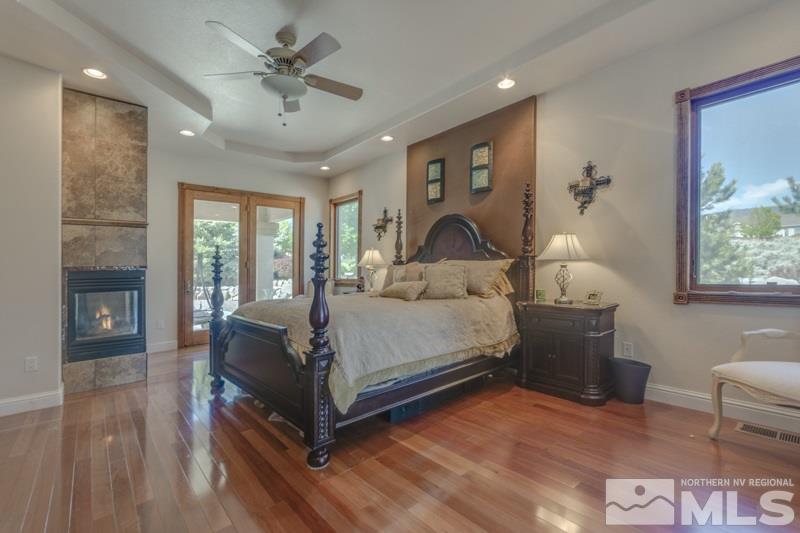 12670 Silver Wolf Road Reno, NV 89511 - Photo 16 of 25 a bedroom with a large bed and a chandelier