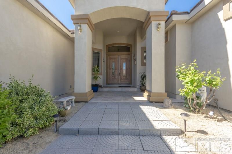 12670 Silver Wolf Road Reno, NV 89511 - Photo 3 of 25 a view of a entryway door with flower in front of a house