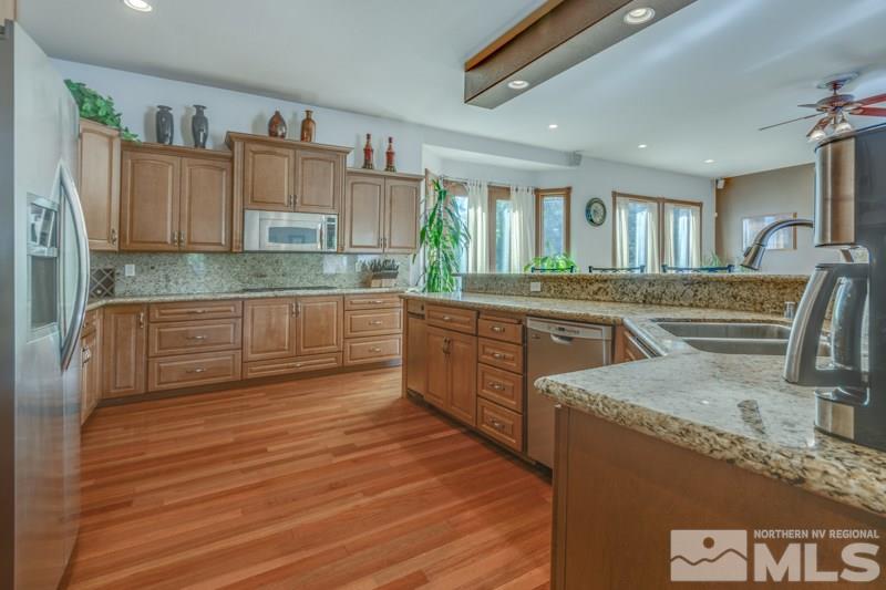 12670 Silver Wolf Road Reno, NV 89511 - Photo 9 of 25 a kitchen with stainless steel appliances granite countertop a sink stove and cabinets