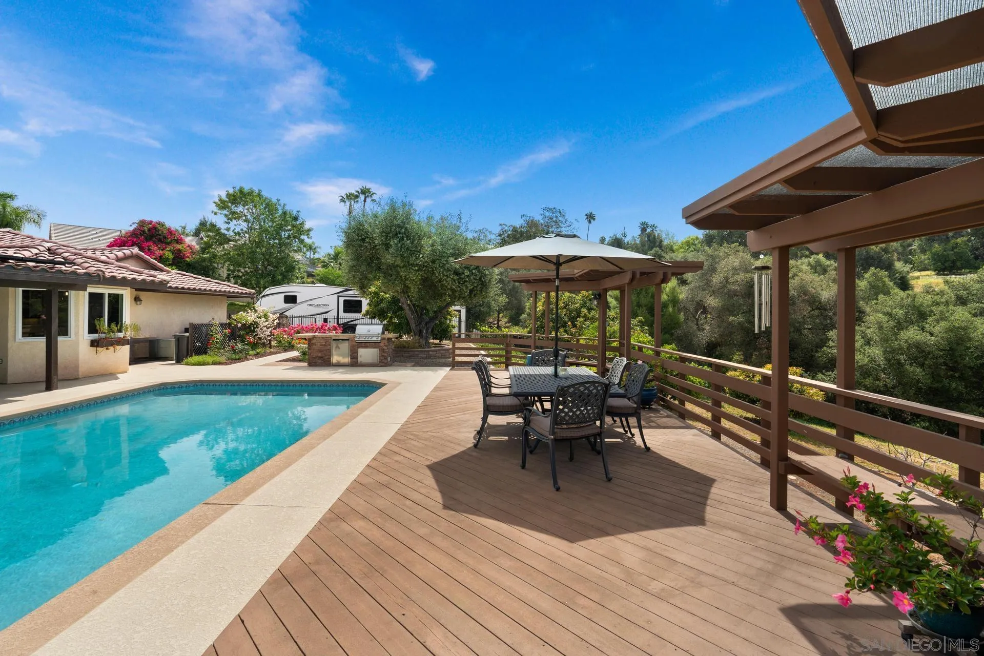 1009 Summit Trail Escondido, CA 92025 - Photo 29 of 59 a view of a patio with table and chairs under an umbrella with wooden floor