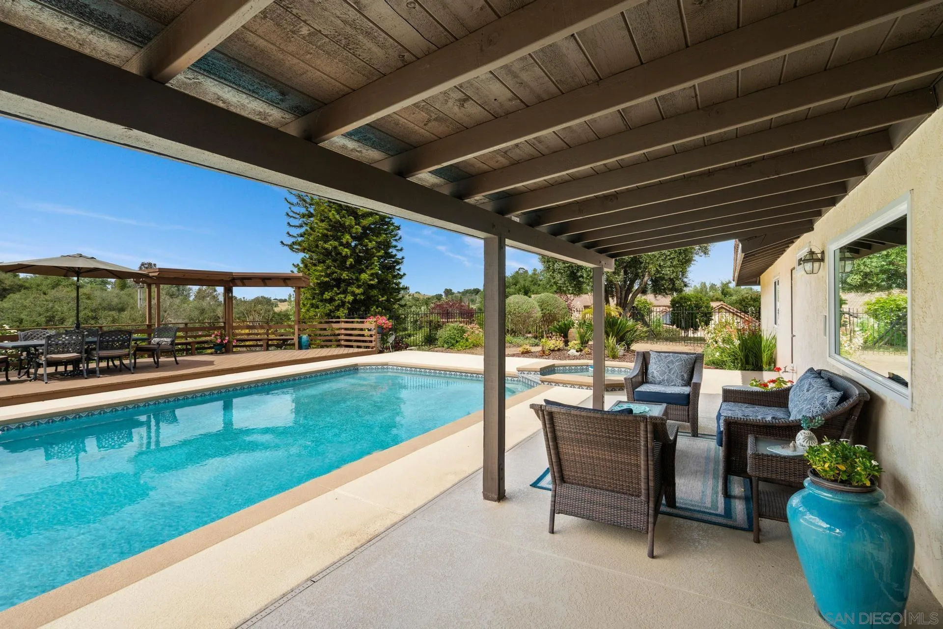1009 Summit Trail Escondido, CA 92025 - Photo 34 of 59 a view of a patio with table and chairs potted plants with floor to ceiling window