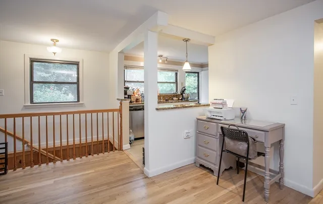 a view of a workspace with furniture and a window