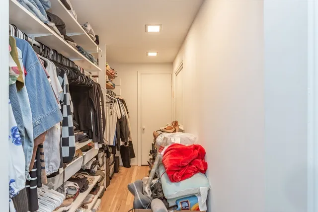 a view of walk in closet with clothes and shoes