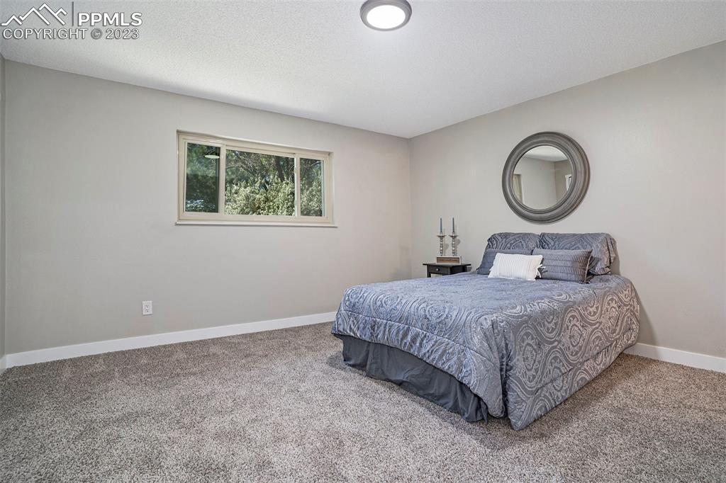 4506 Ridgecrest Drive Colorado Springs, CO 80918 - Photo 12 of 29 a bedroom with a bed and a large mirror