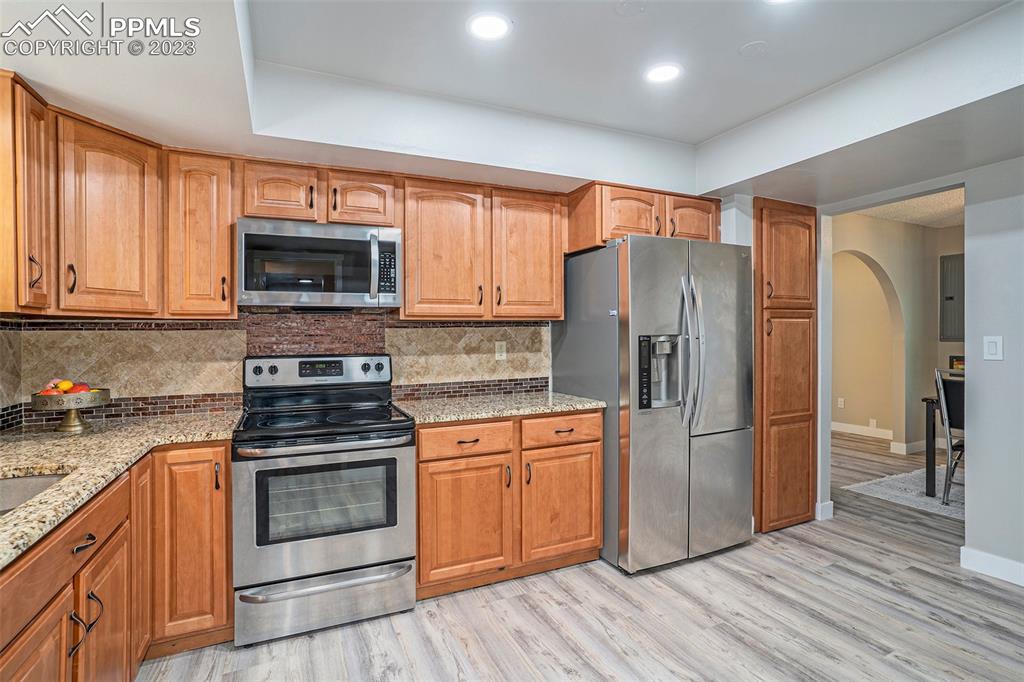 4506 Ridgecrest Drive Colorado Springs, CO 80918 - Photo 9 of 29 a kitchen with a refrigerator stove and wooden cabinets