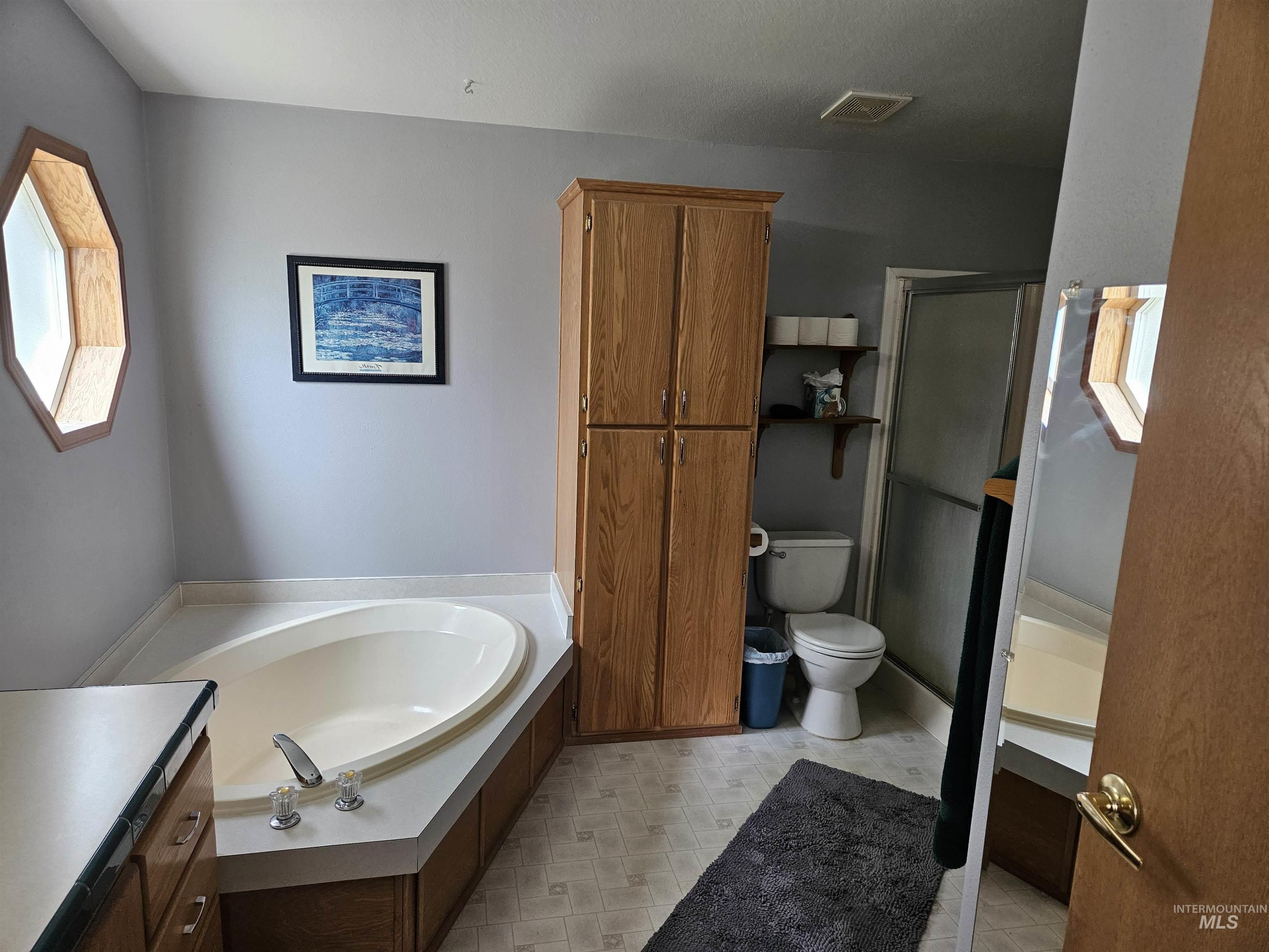 232 Lackey Road Weippe, ID 83553 - Photo 11 of 33 Full bathroom with a garden tub, a shower stall, and vanity