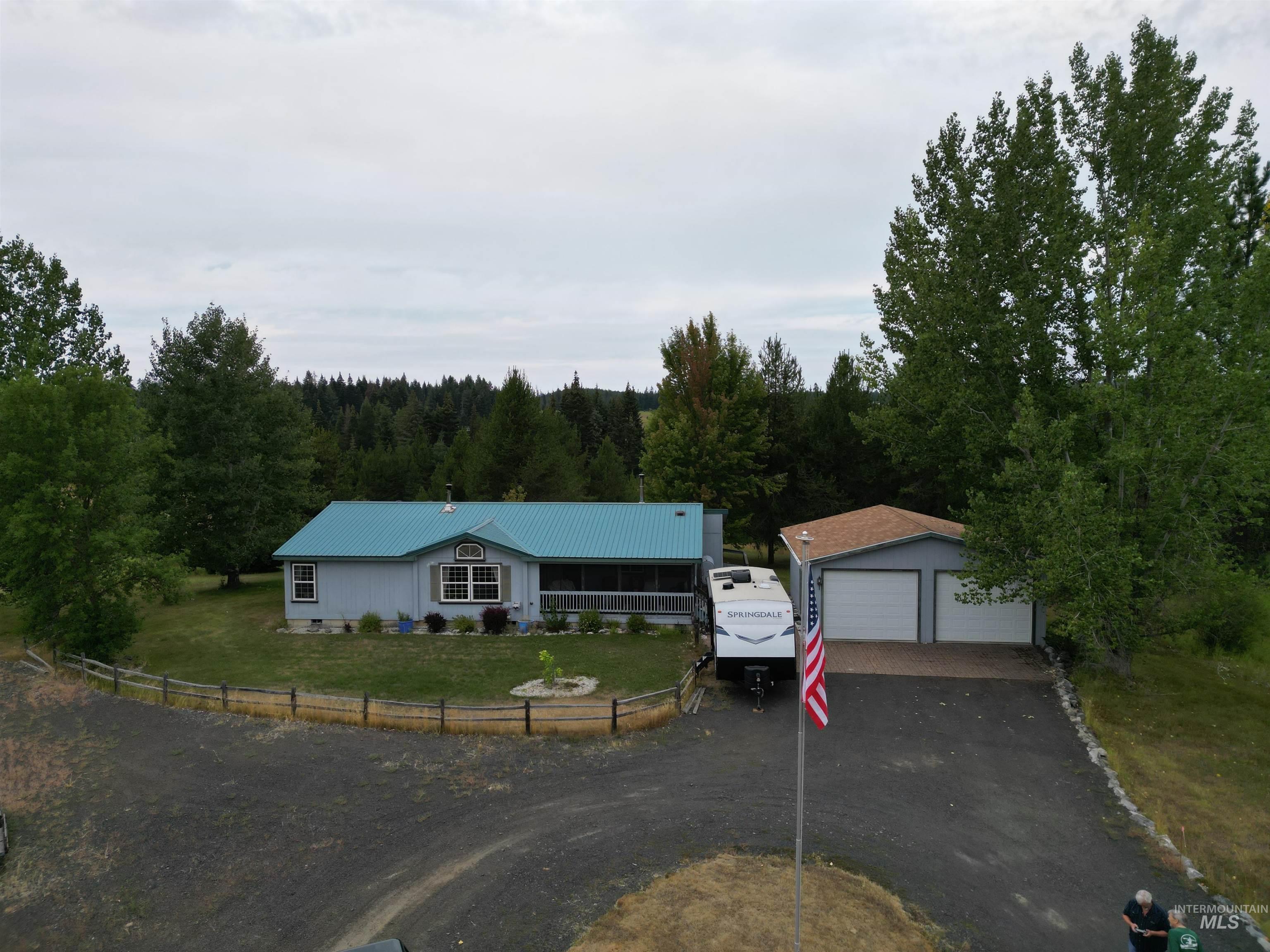 232 Lackey Road Weippe, ID 83553 - Photo 13 of 33 Ranch-style house featuring an outbuilding, a detached garage, a metal roof, and a forest view