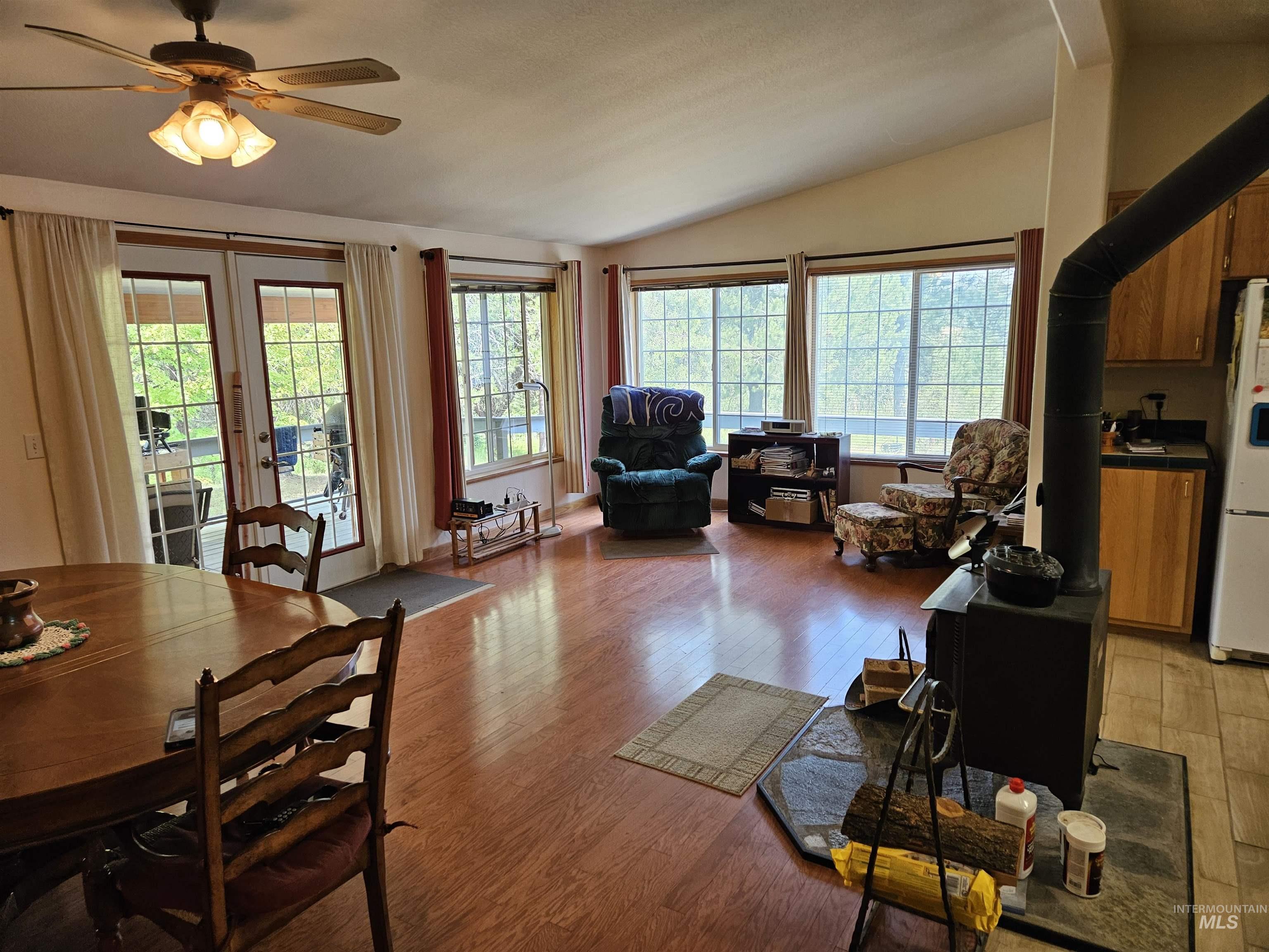 232 Lackey Road Weippe, ID 83553 - Photo 4 of 33 Dining room with a wood stove, vaulted ceiling, light wood-style flooring, and a ceiling fan