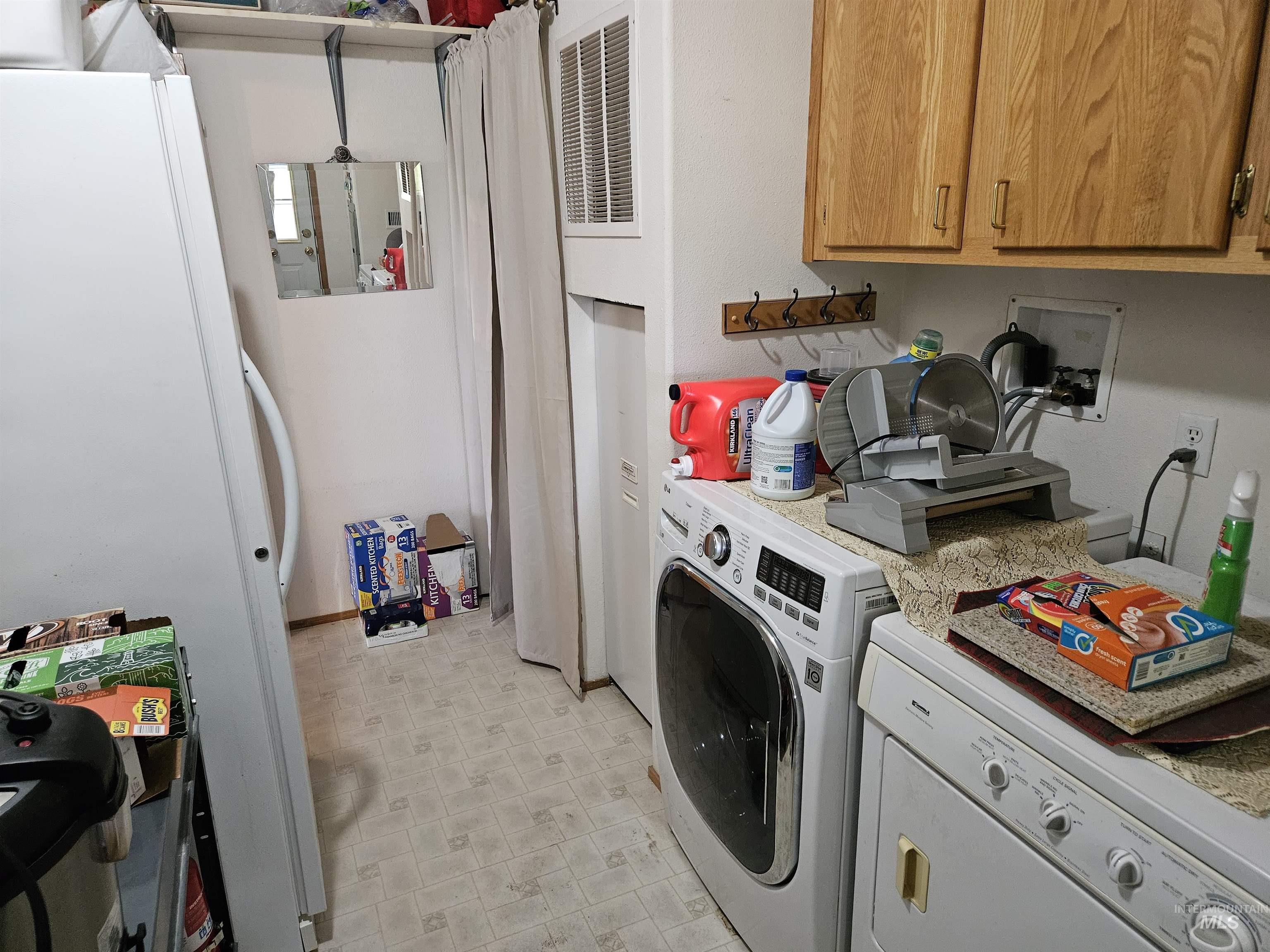 232 Lackey Road Weippe, ID 83553 - Photo 6 of 33 Washroom featuring washer and dryer, cabinet space, a heating unit, and light flooring
