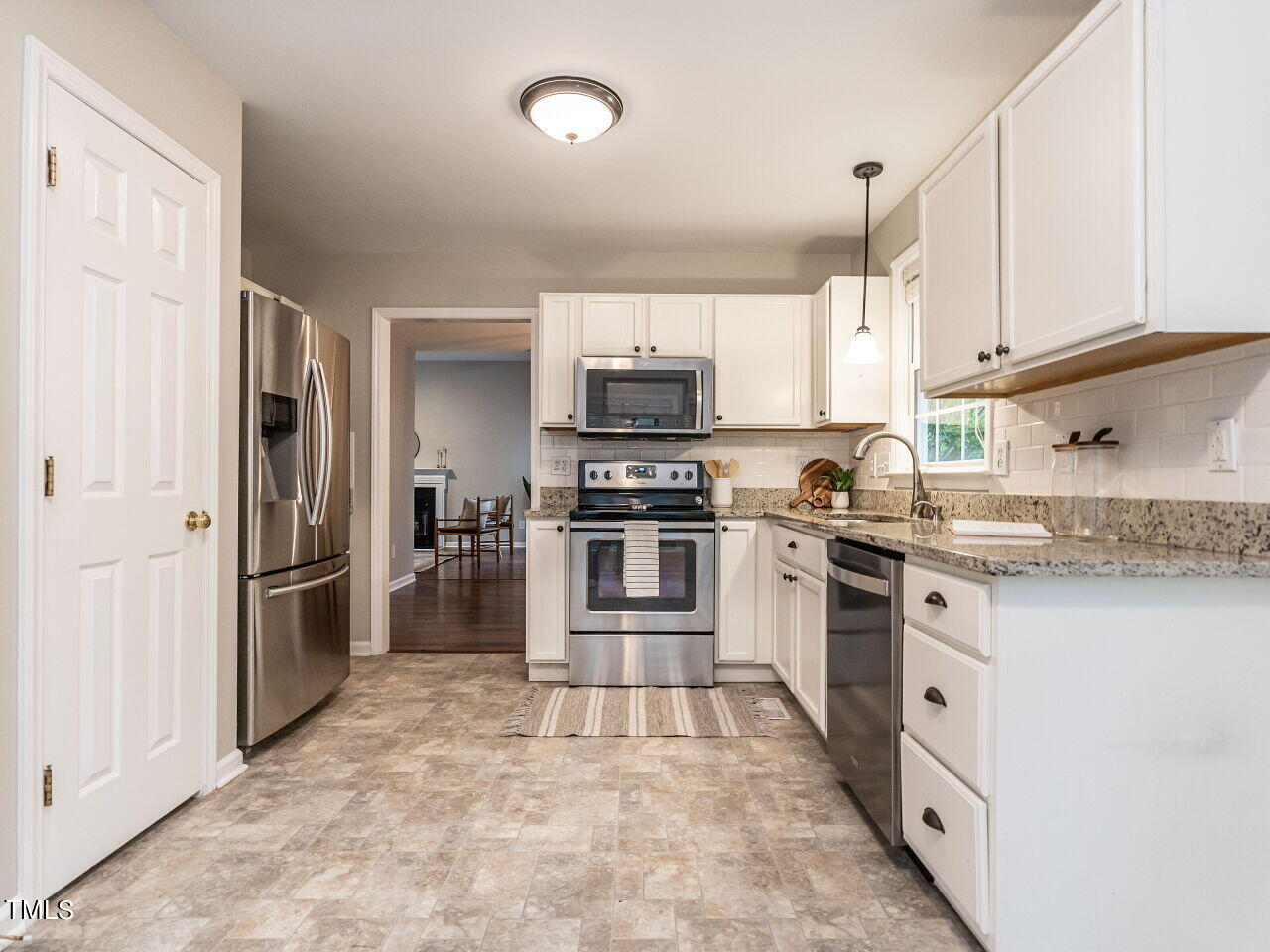 3 Madeira Court Durham, NC 27713 - Photo 12 of 27 a kitchen with granite countertop a refrigerator and a stove top oven