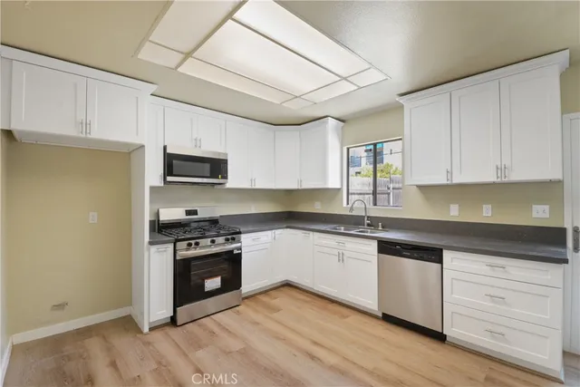 a kitchen with stainless steel appliances granite countertop a stove sink microwave and cabinets