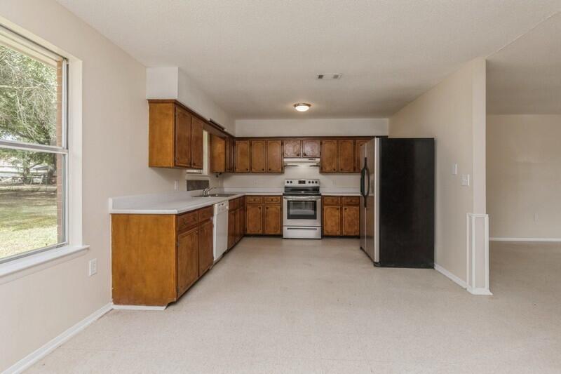 3369 Auburn Road Crestview, FL 32539 - Photo 11 of 33 a kitchen with stainless steel appliances kitchen island granite countertop a refrigerator and a stove top oven