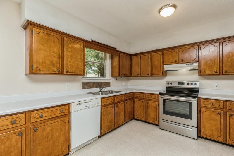 3369 Auburn Road Crestview, FL 32539 - Photo 13 of 33 a kitchen with stainless steel appliances granite countertop a stove sink and cabinets