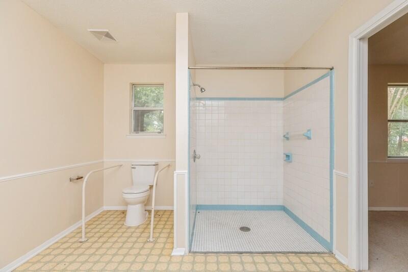 3369 Auburn Road Crestview, FL 32539 - Photo 25 of 33 a bathroom with a glass door shower and a toilet