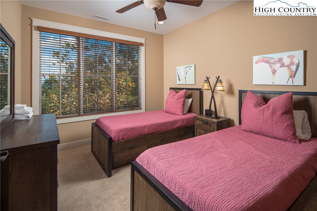 1253 Goldenrod Road Boone, NC 28607 - Photo 24 of 48 a bedroom with two beds and a chandelier