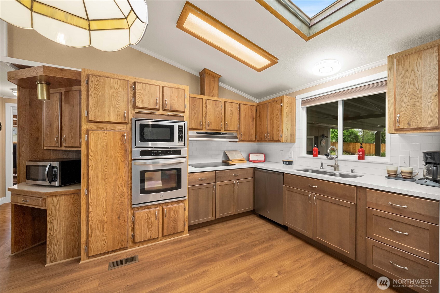 836 Harman Way South, Unit 62 Orting, WA 98360 - Photo 17 of 40 a kitchen with stainless steel appliances granite countertop a refrigerator and a stove top oven
