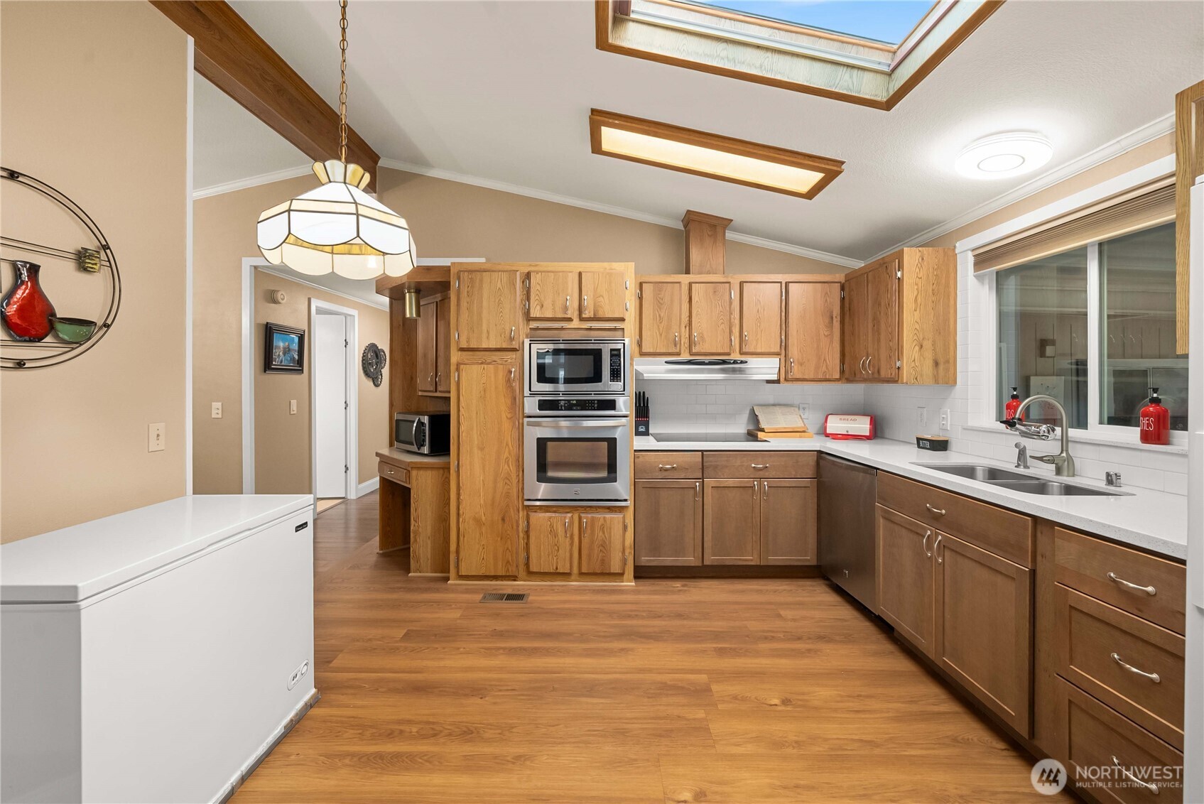 836 Harman Way South, Unit 62 Orting, WA 98360 - Photo 18 of 40 a kitchen with a refrigerator sink and wooden cabinets