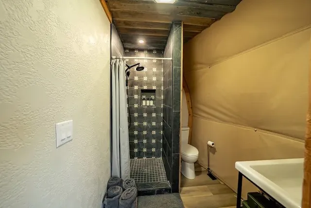 a bathroom with a toilet and a shower