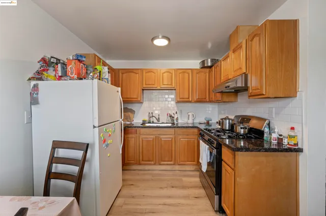 a kitchen with a refrigerator a sink and wooden cabinets