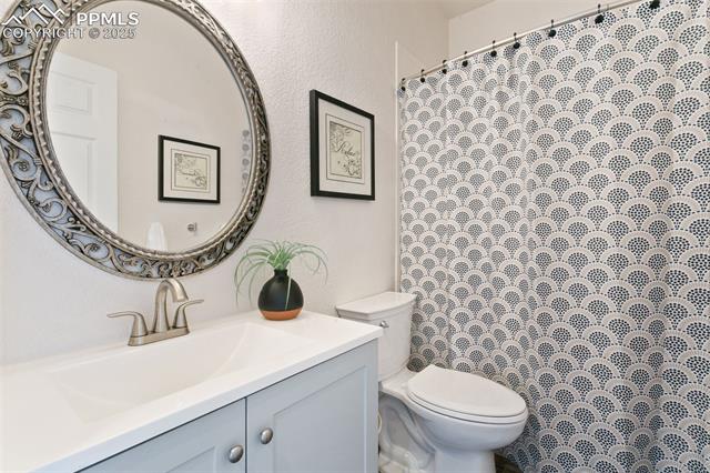 13775 Woodlake Road Elbert, CO 80106 - Photo 27 of 44 Full bathroom with vanity, a textured wall, and curtained shower