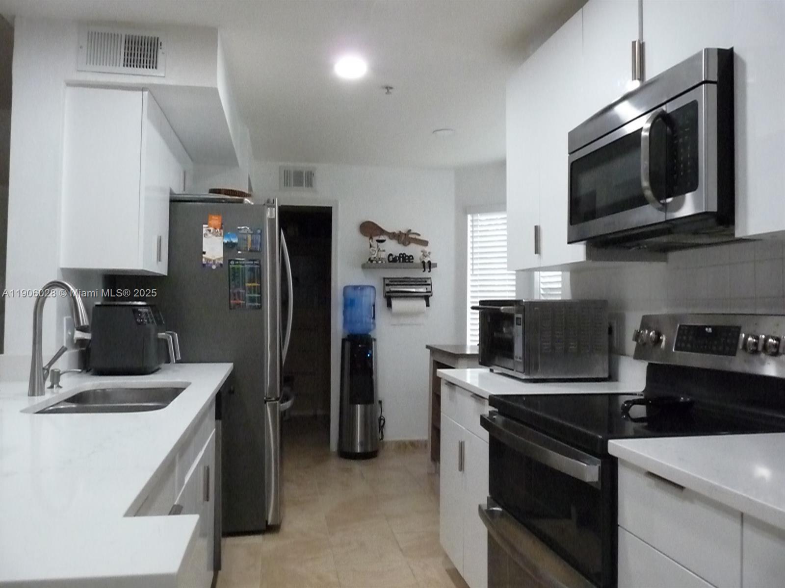 400 Summit Ridge Place, Unit 216 Longwood, FL 32779 - Photo 2 of 25 a kitchen with stainless steel appliances a stove microwave and refrigerator