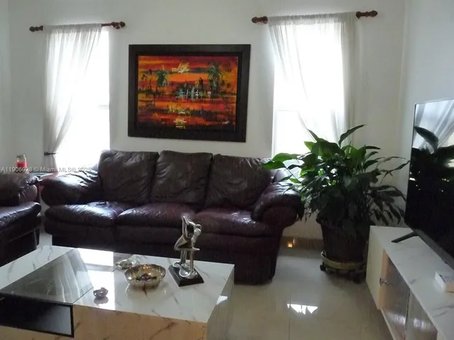 a living room with furniture potted plant and a window
