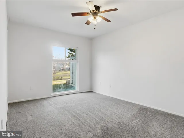 a view of room with ceiling fan and window