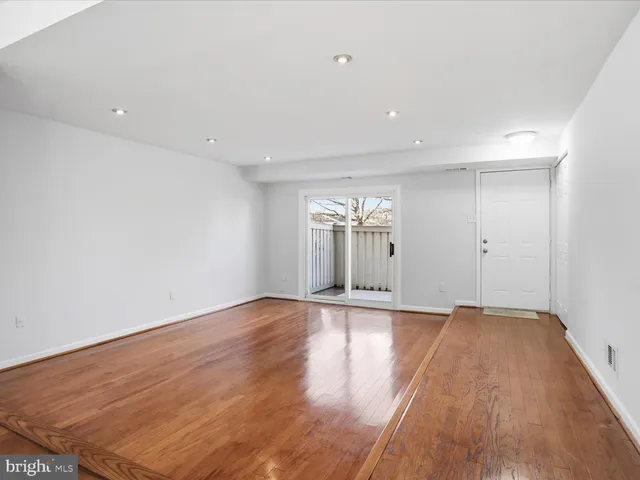 an empty room with wooden floor and chandelier