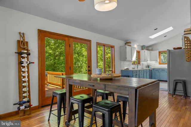 a kitchen with stainless steel appliances granite countertop a table chairs refrigerator and sink