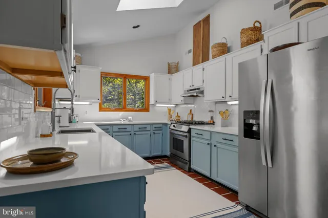 a kitchen with stainless steel appliances a sink a stove a refrigerator and cabinets