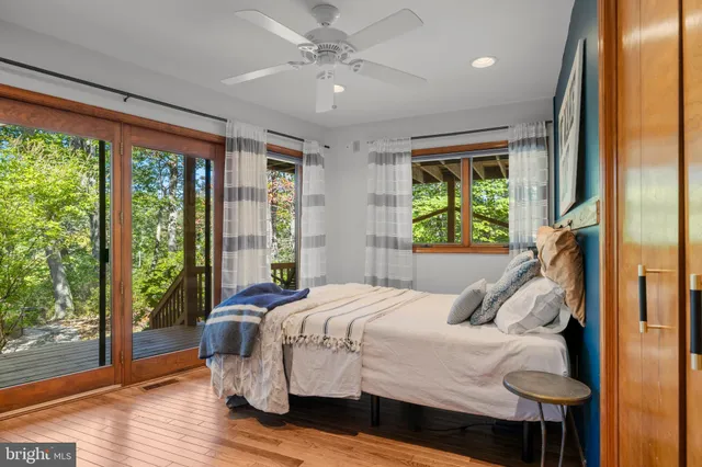 a bedroom with a bed and a large window with outer view