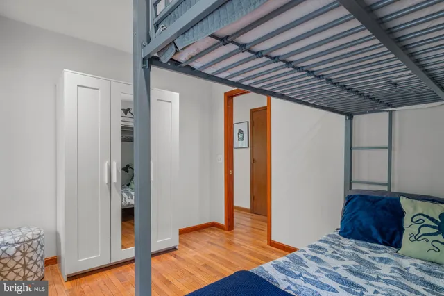 a bedroom with a bed and wooden floor