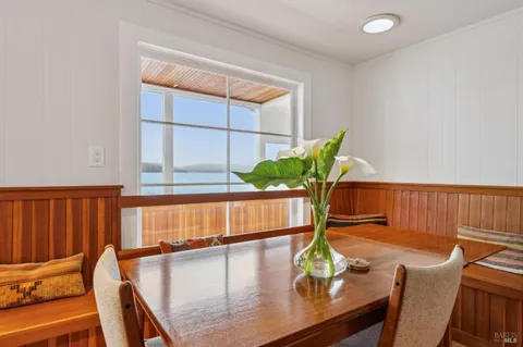 a view of a dining room with furniture a potted plant and wooden floor