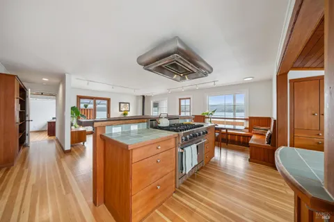 a kitchen with stainless steel appliances granite countertop a stove and a wooden floors