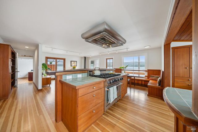 a kitchen with stainless steel appliances granite countertop a stove and a wooden floors