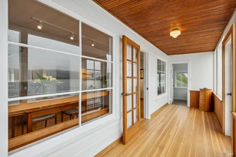 a view of a balcony with wooden floor and glass door